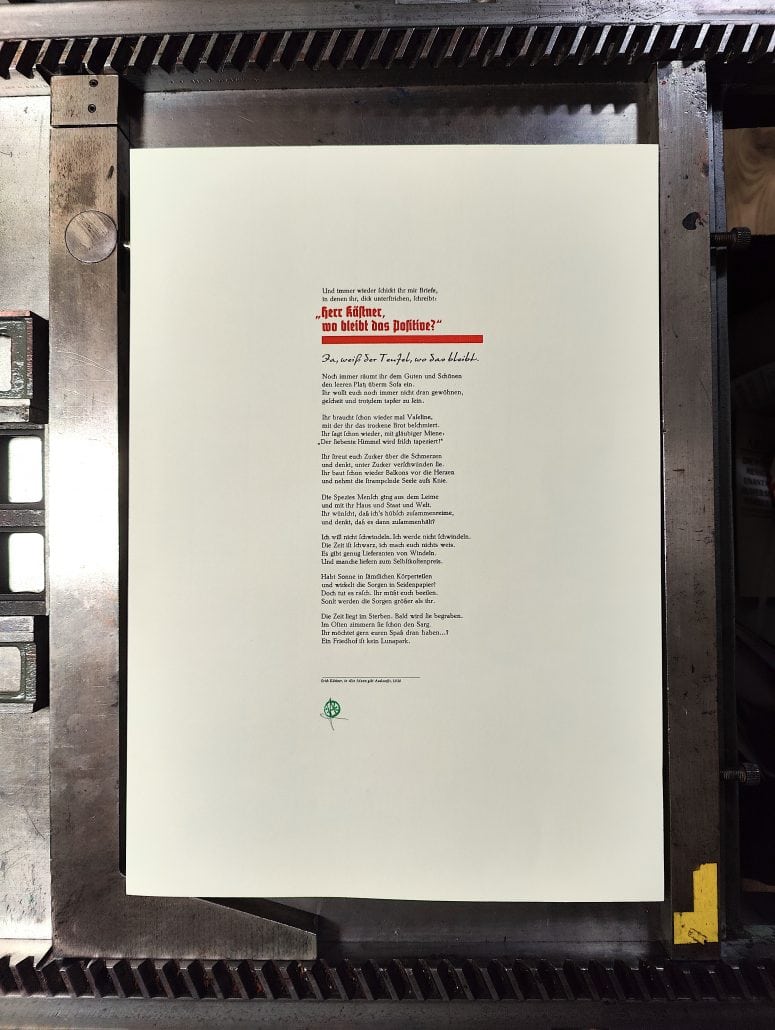 Gedicht auf weißem Hintergrund, umrahmt von Druckmaschine.