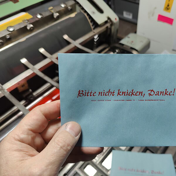 Foto eines blauen Umschlages mit Hinweisaufdruck