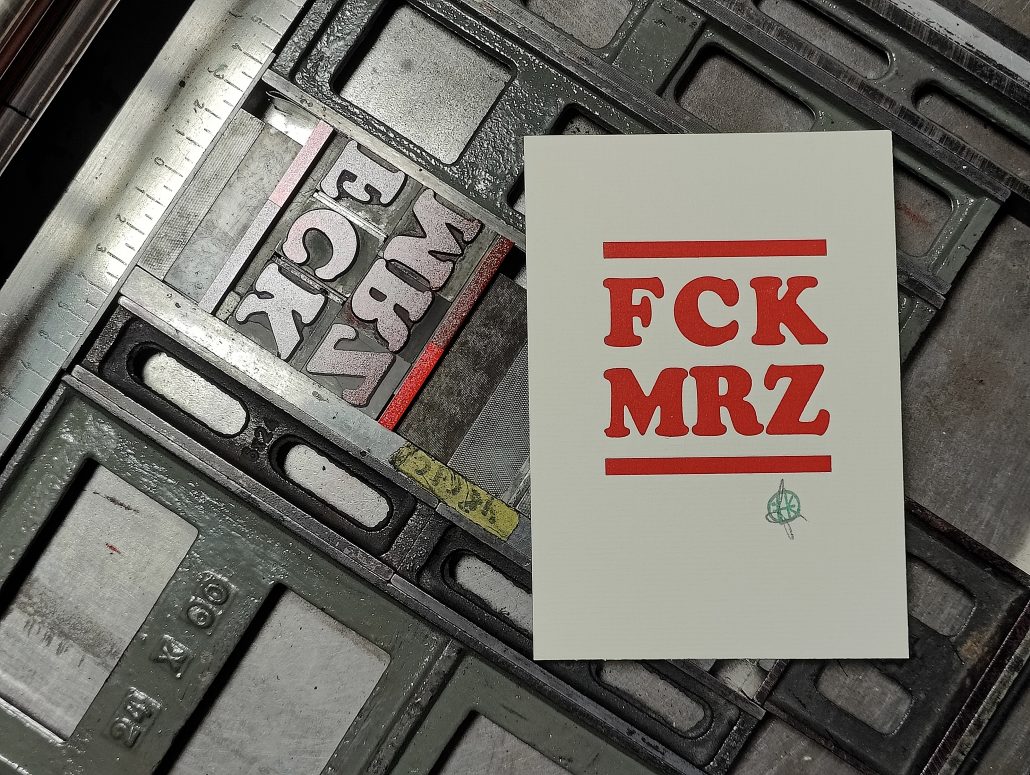 Foto Karte mit dem Aufdruck FCK MRZ neben der Druckform