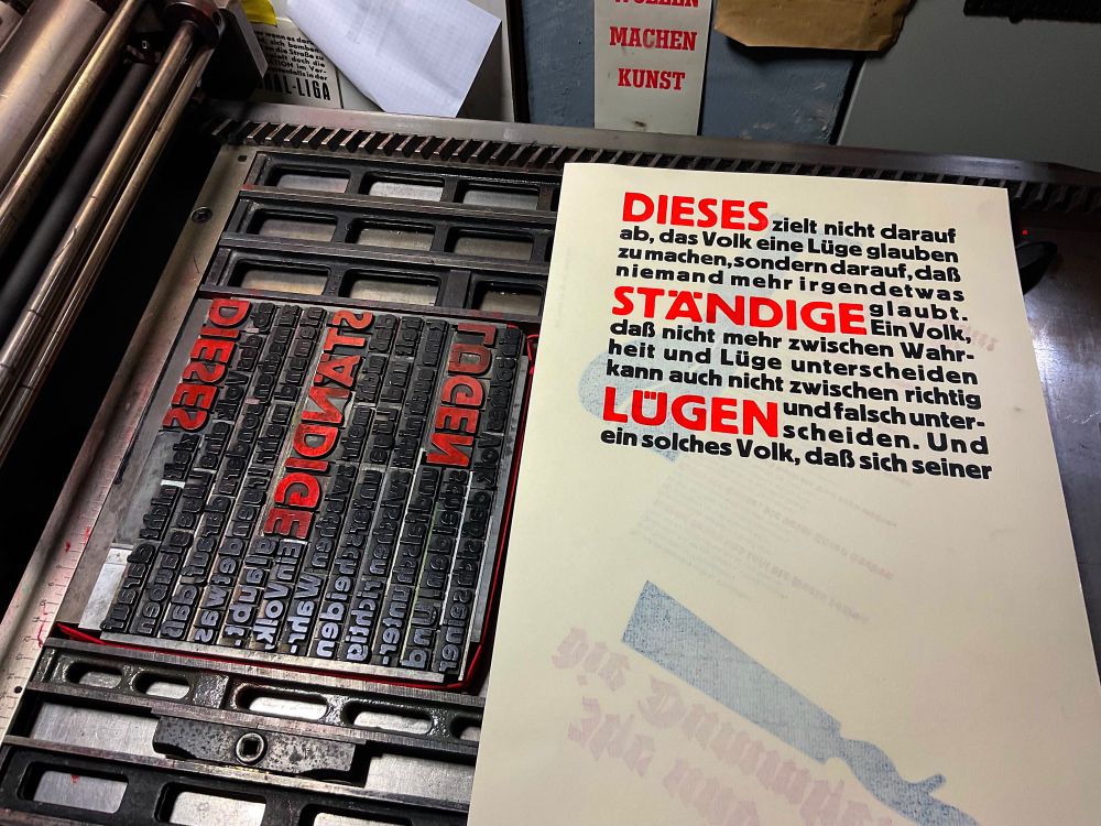 Foto eines zweifarbigen Musterabzuges neben der zweifarbig eingefärbten Bleisatzform.