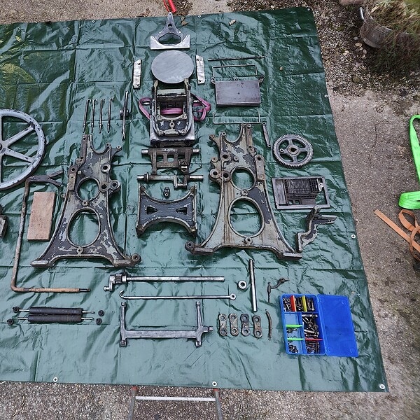 Motorradteile auf grüner Plane, Werkstatt- oder Reparaturumgebung.