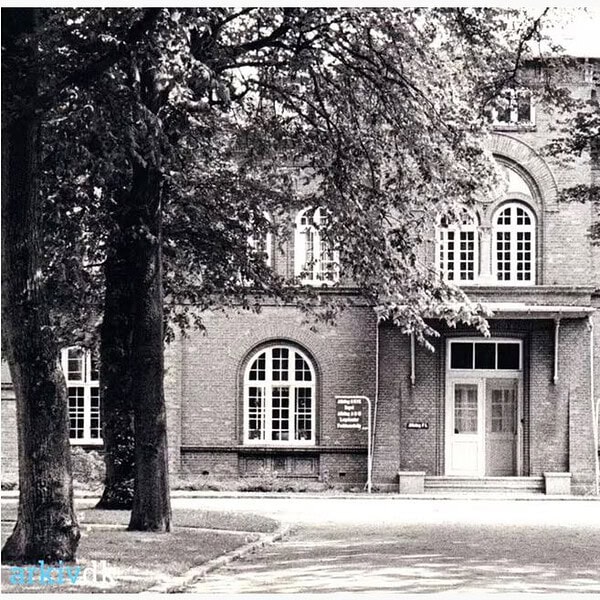 Historisches Gebäude mit Bäumen vor dem Eingang, Frau Eickhoffs alter Arbeitsplatz.