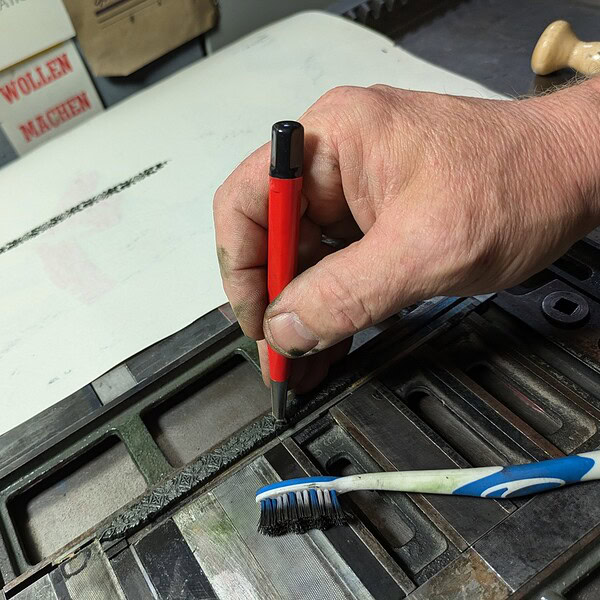 Hand mit Schraubenzieher bei Reparatur an einem defekten Gerät.
