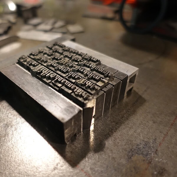 Metallstempel mit eingraviertem Text auf Werkbank.