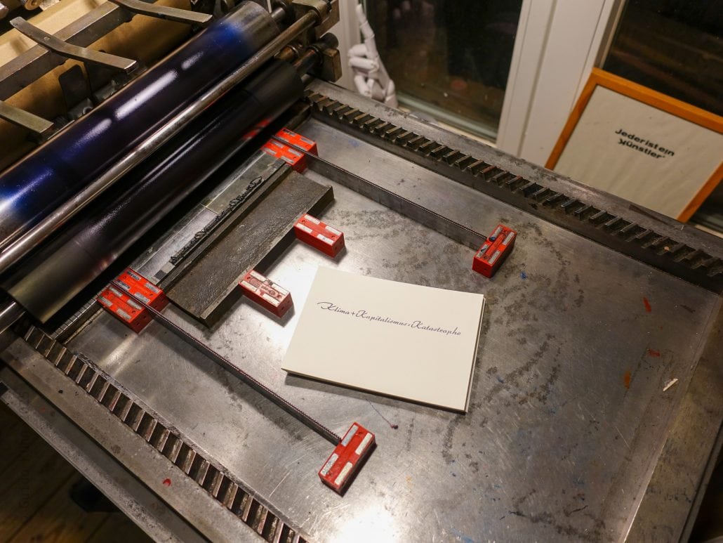 Druckmaschine mit Papier und Klammern in einer Druckerei.