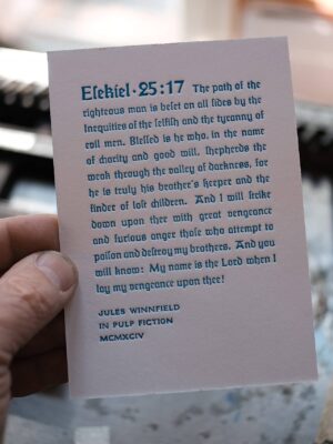 Hand hält eine Karte mit Bibelvers Esekiel 25:17 in einem Auto.