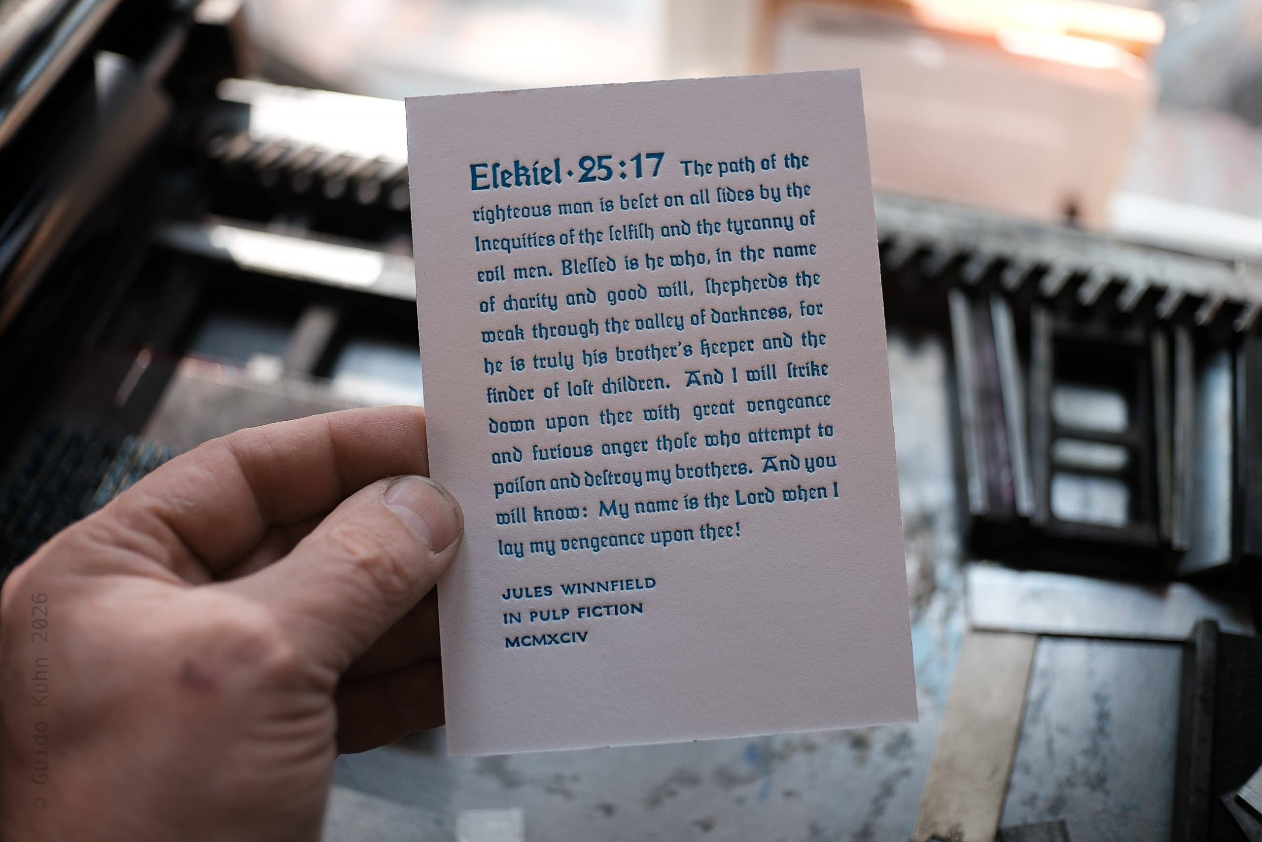 Hand hält eine Karte mit Bibelvers Esekiel 25:17 in einem Auto.