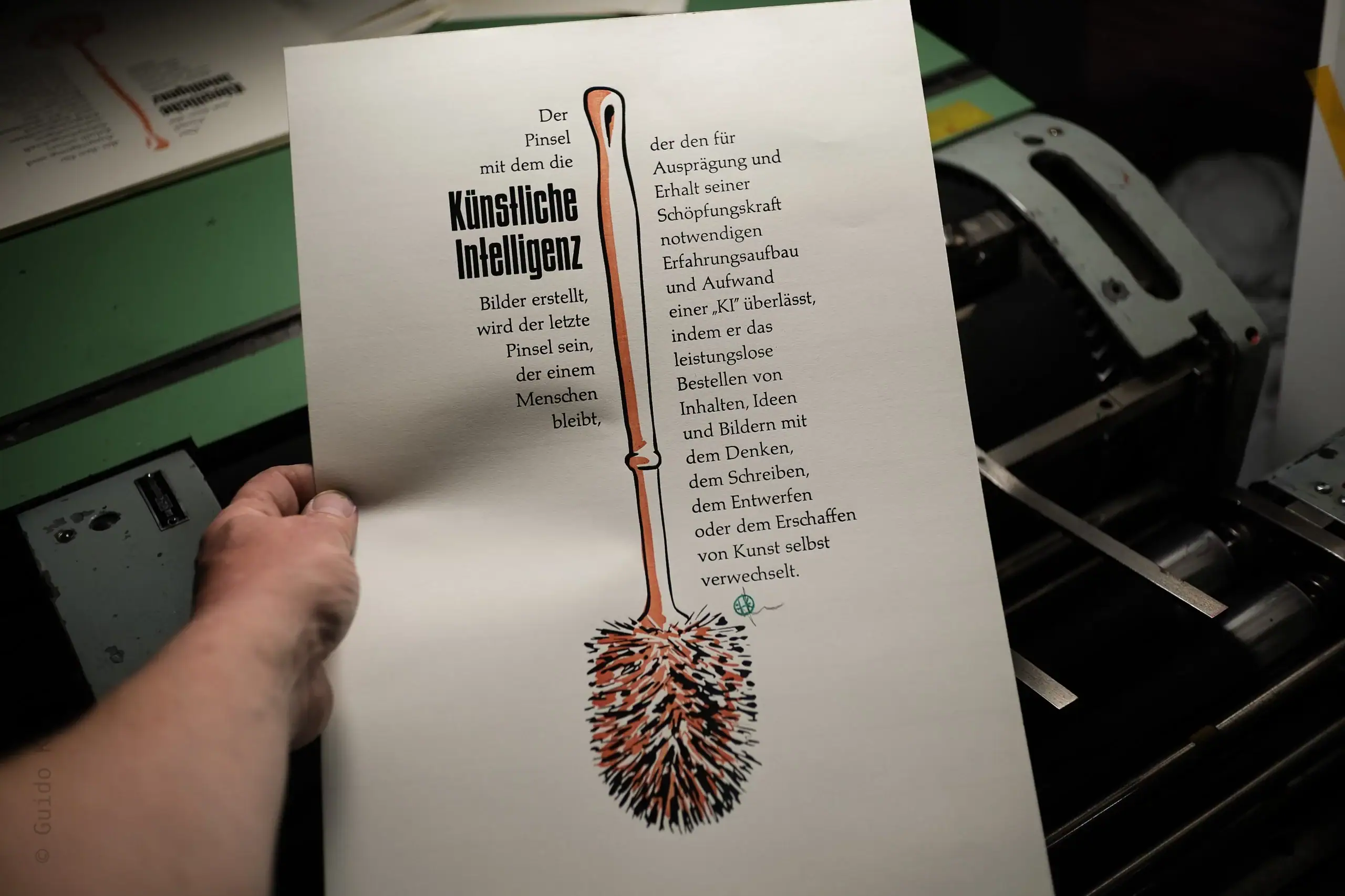 Foto mit dem fertigen Abzug. Man sieht einen Formtext um eine Klobürste. Der Text lautet: Der Pinsel mit dem die Künstliche Intelligenz Bilder erstellt, wird der letzte Pinsel sein, der einem Menschen bleibt, der den für Ausprägung und Erhalt seiner Schöpfungskraft notwendigen Erfahrungsaufbau und Aufwand einer „KI“ überlässt, indem er das leistungslose Bestellen von Inhalten, Ideen und Bildern mit dem Denken, dem Schreiben, dem Entwerfen oder dem Erschaffen von Kunst verwechselt.