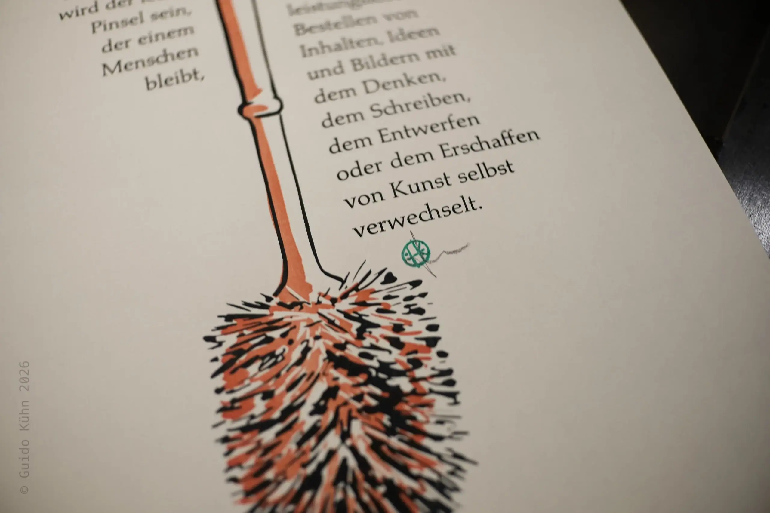Foto mit einem Detail des Drucks. Man sieht zweifarbig rot-Schwarz eine Klobürste und Text.