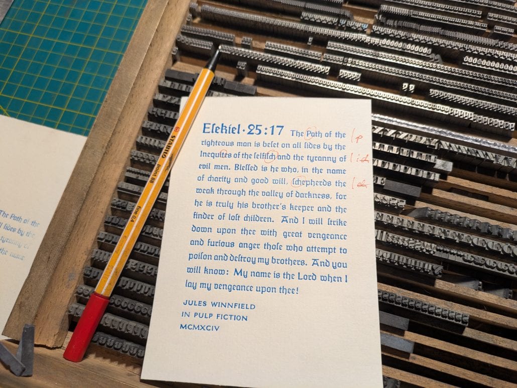 Handschriftliche Notiz zu Ezechiel 25:17 auf Papier mit Schreibutensilien.