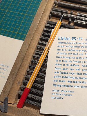 Handschriftliche Notiz zu Ezechiel 25:17 auf Papier mit Schreibutensilien.