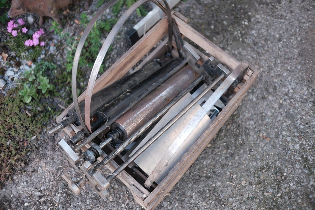 Altes, rostiges Werkzeug in einer Holzkiste auf dem Boden.