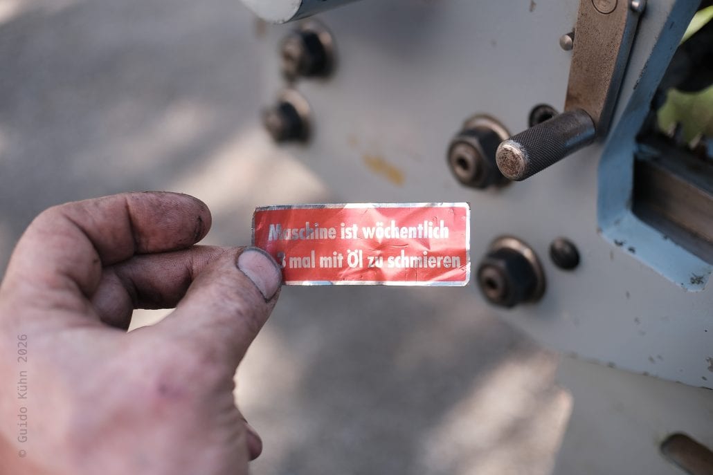 Männliche Hand hält Warnschild mit Öl-Informationen bei Stuttgart 2.