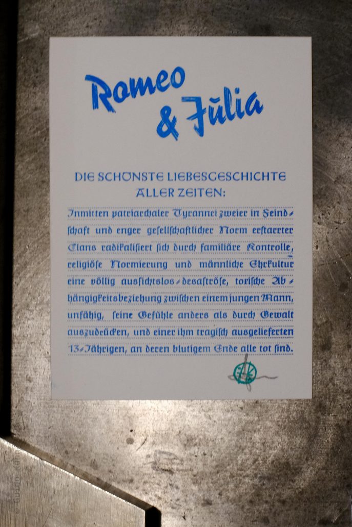 Handgeschriebener Titel 'Romeo & Julia' auf weißem Papier, mit Text über die Liebesgeschichte.
